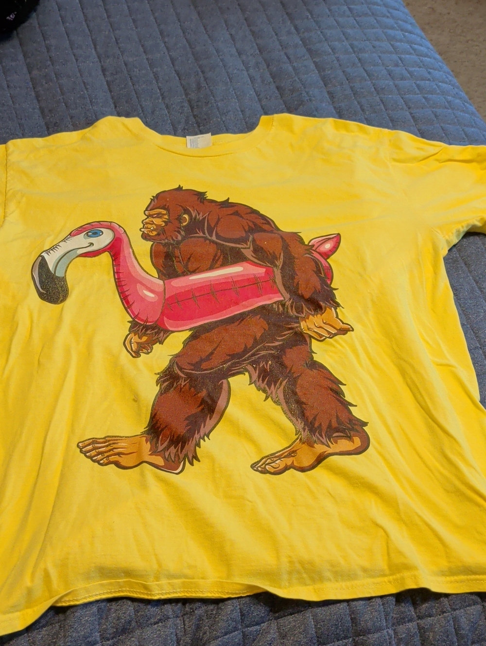 Port and Company Yellow T-Shirt with Bigfoot Carrying Pink Flamingo Float